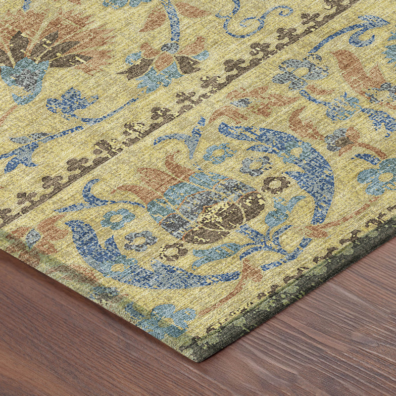 Corner view of gold and teal blue distressed floral area rug with bordered design