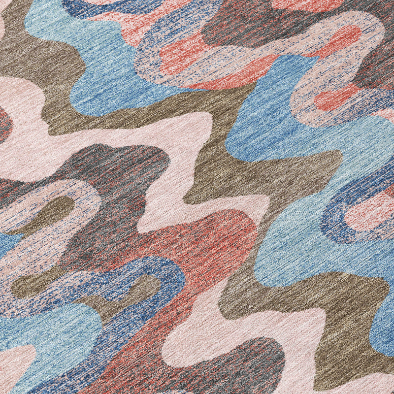 Textured multicolor zigzag area rug close-up with blue, coral, pink, and gray shapes.