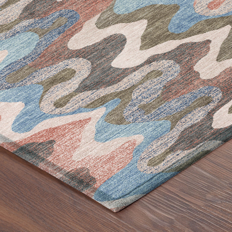 Multicolor abstract zigzag area rug corner on dark wood floor, pink coral blue gray.