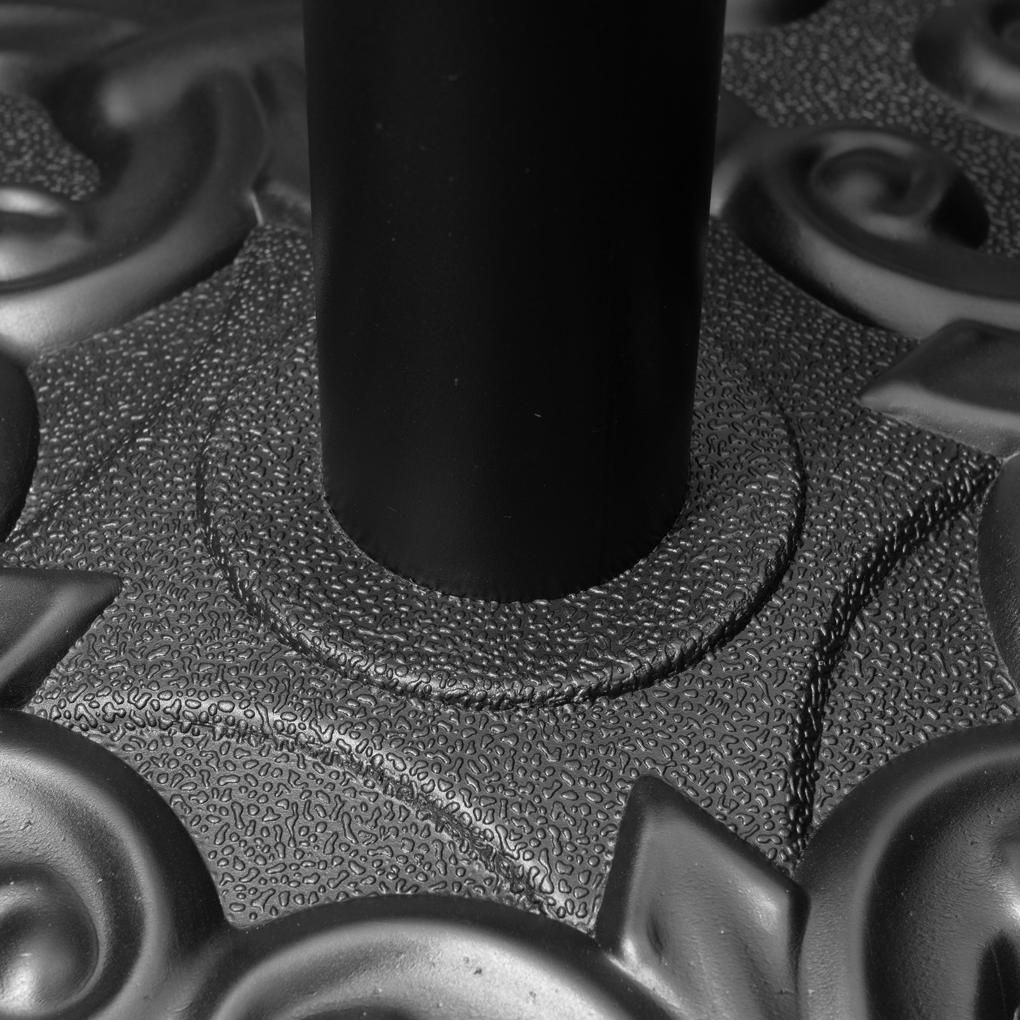 Umbrella base with central pole and textured circular top, black steel.