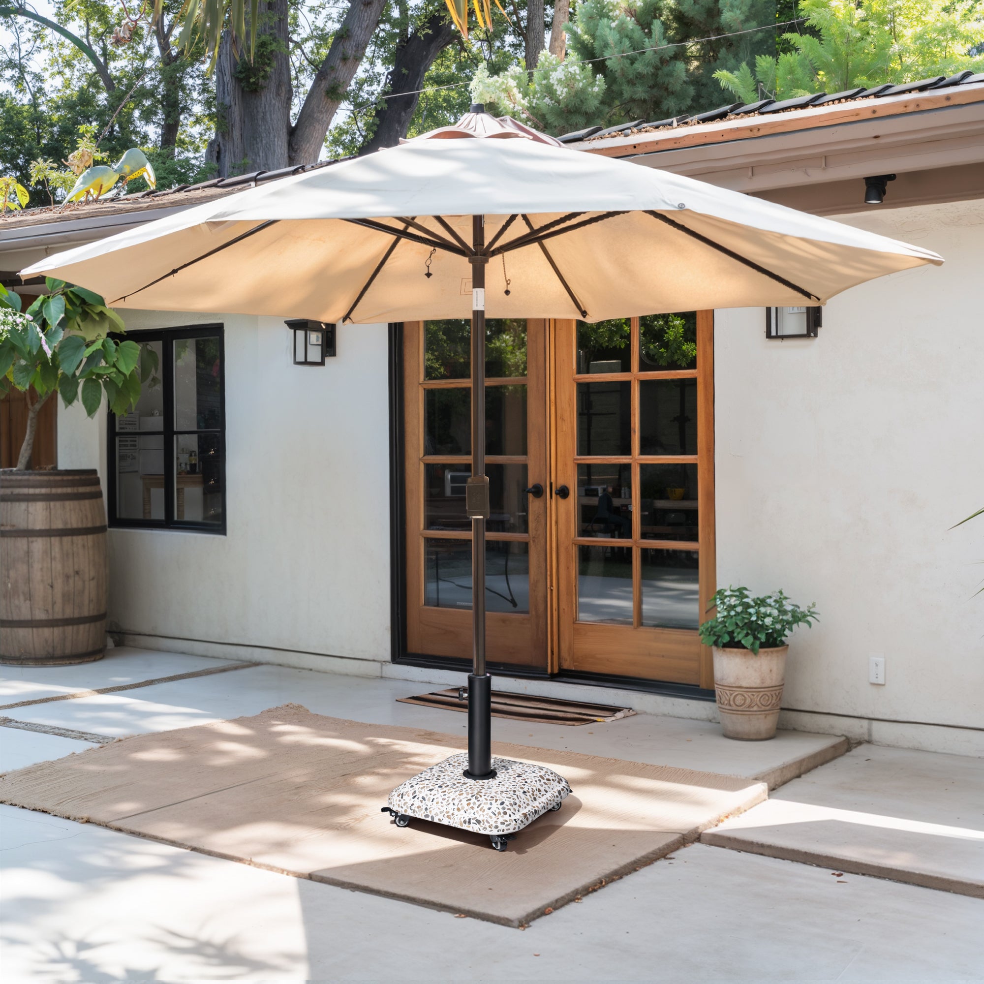 Umbrella base on patio with black pole and speckled weighted cover