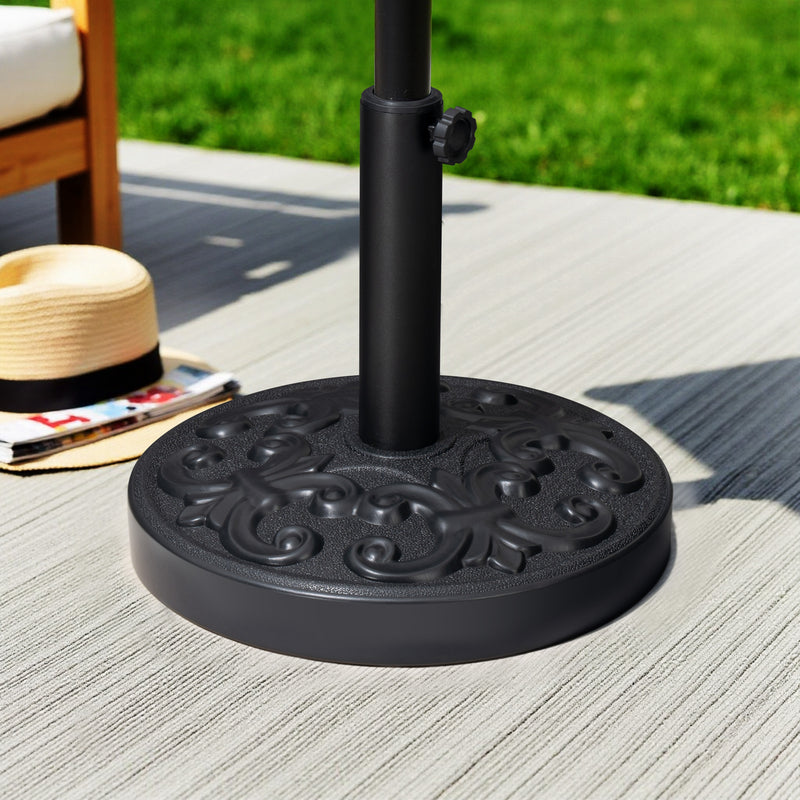 Black umbrella base with central pole and decorative top plate, upright on a surface.