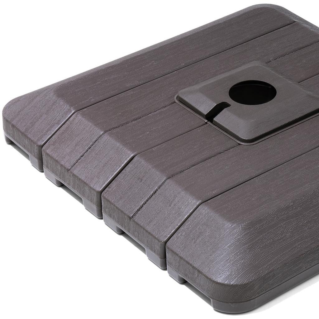 Close-up umbrella base top with round fill opening and lever slot, dark gray
