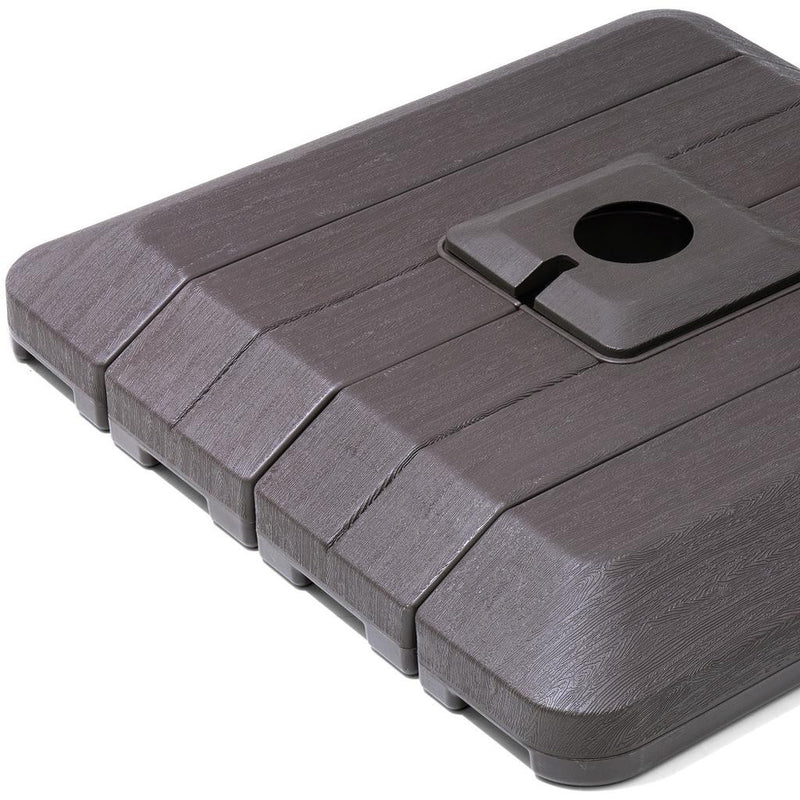 Close-up umbrella base top with round fill opening and lever slot, dark gray