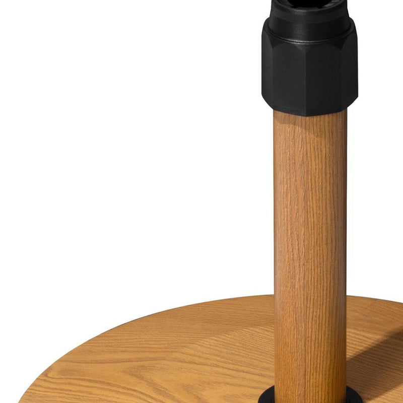 Light brown wooden pole section with black top sleeve on umbrella base with casters