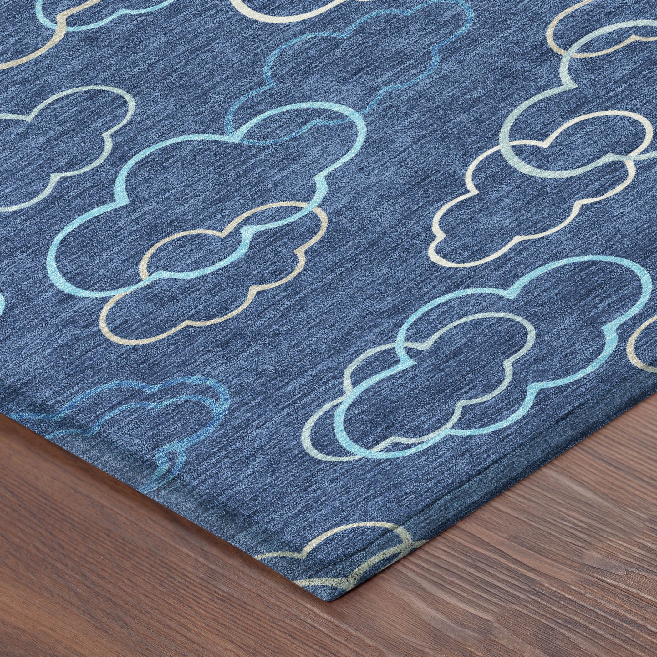Navy area rug corner with teal and ivory cloud line pattern; washable