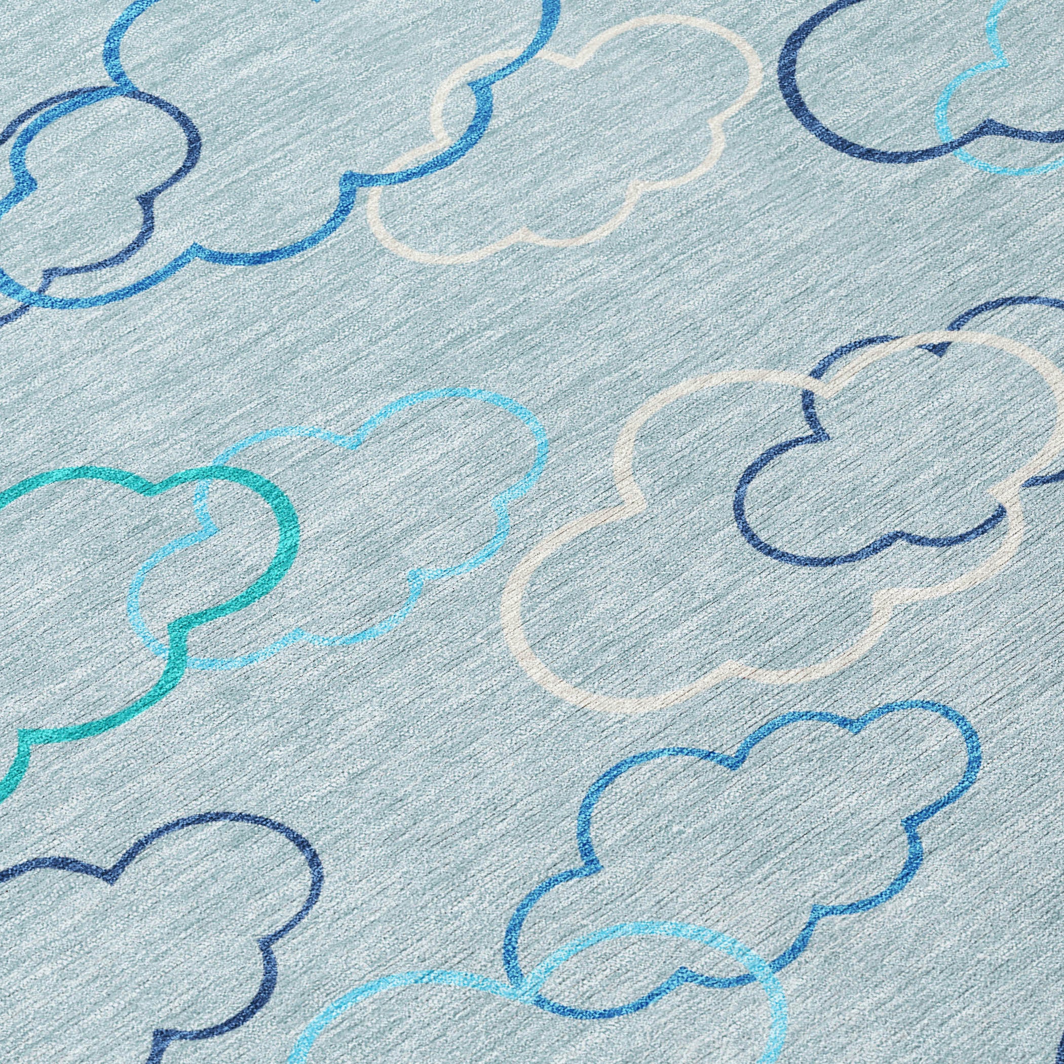 Close-up of sky blue rug with navy and teal cloud outlines on light grey