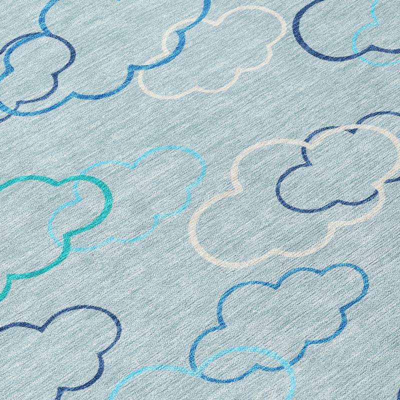 Close-up of sky blue rug with navy and teal cloud outlines on light grey
