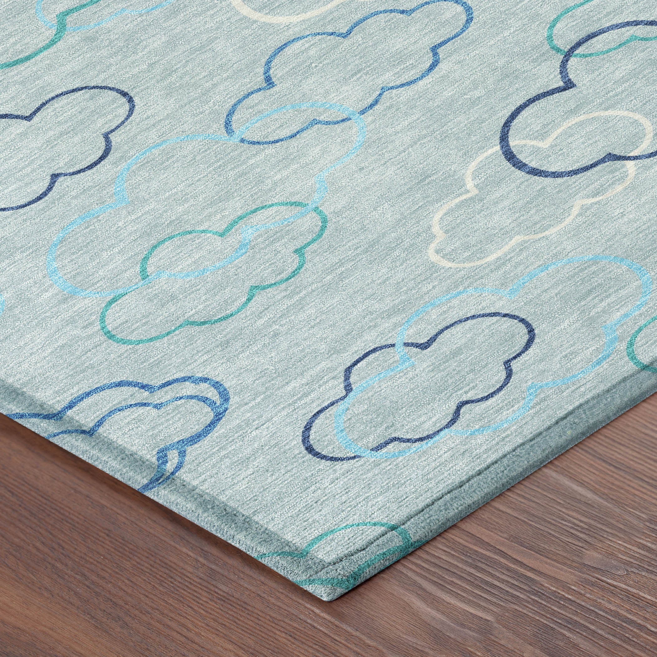 Sky blue area rug corner detail with cloud outline pattern in navy and teal