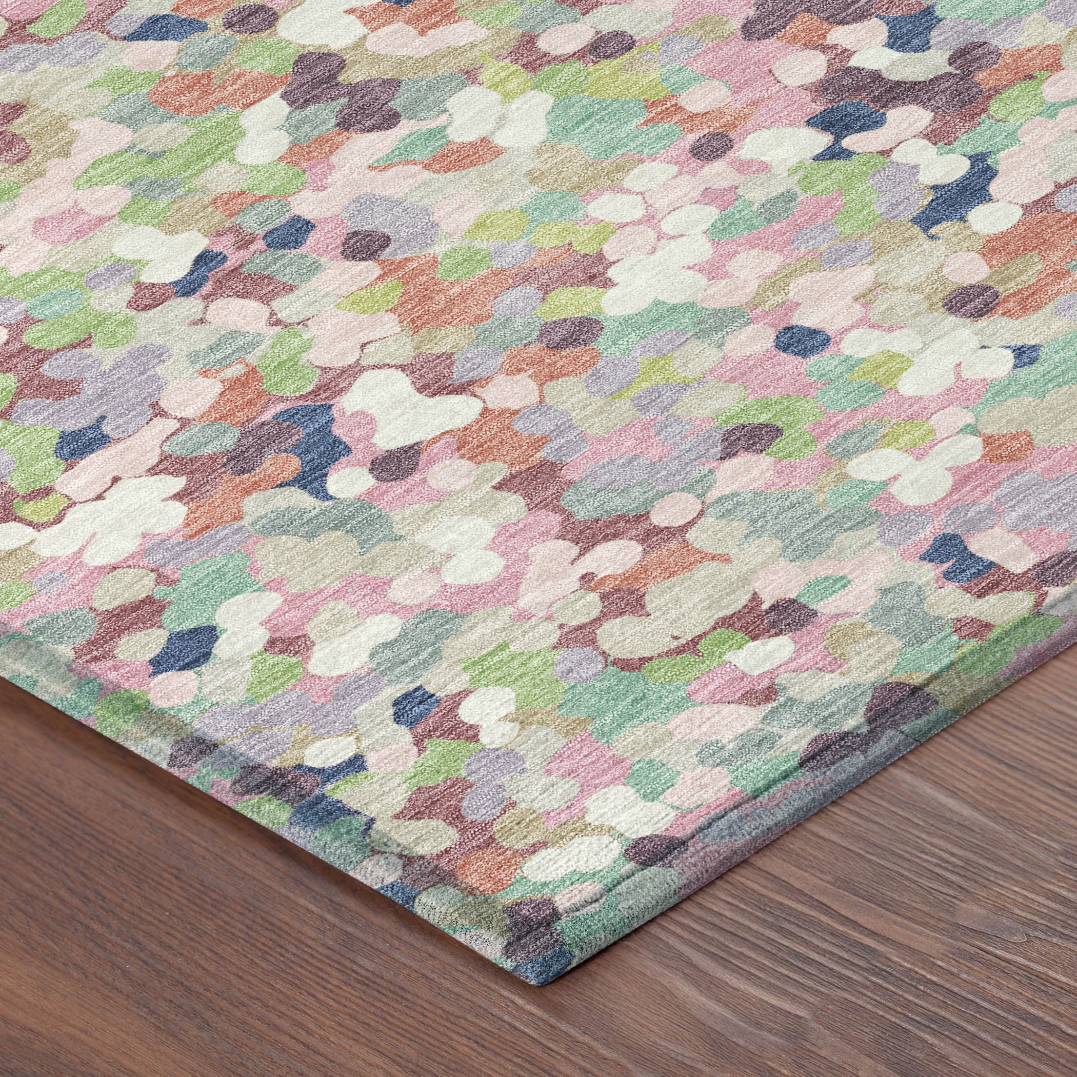 Pastel geometric confetti area rug corner with low-pile texture; blush, pink, blue, green
