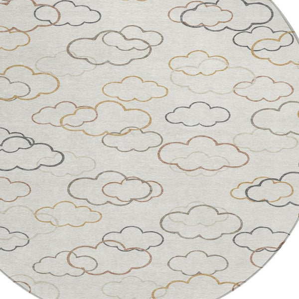Round area rug with light gray cloud outline pattern in beige, tan, and blue-gray