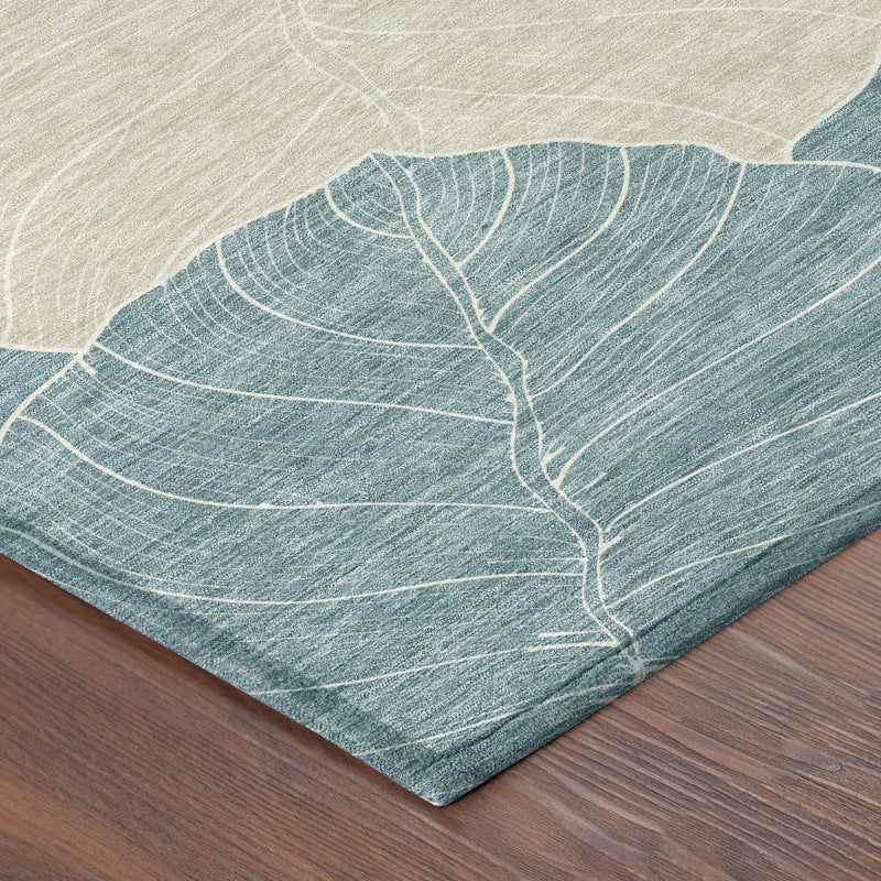 Round teal and ivory leaf-pattern area rug corner on wooden floor