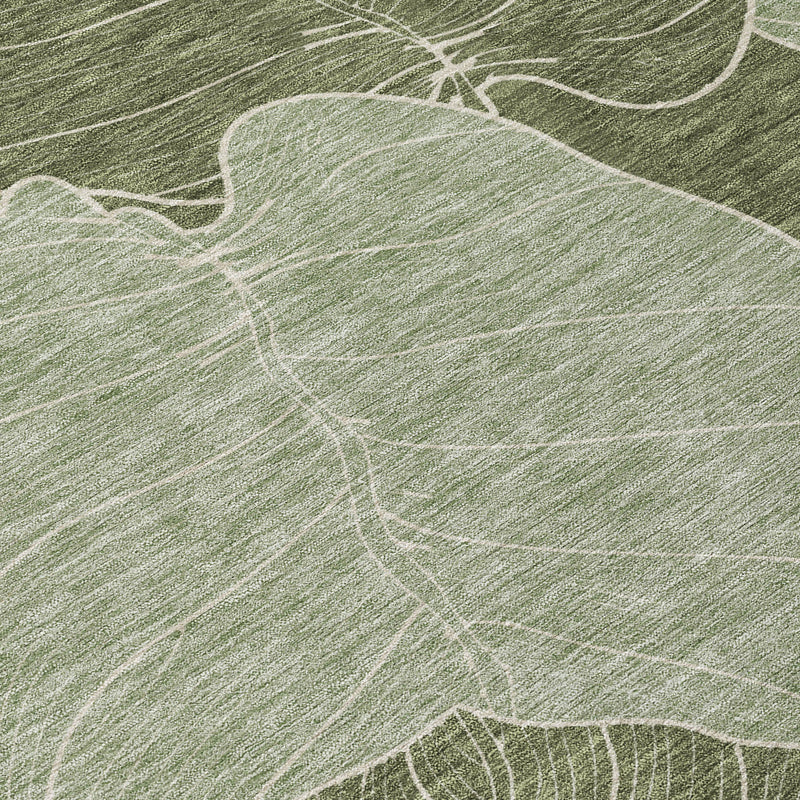 Olive green area rug corner with ivory leaf pattern, laid on wood floor