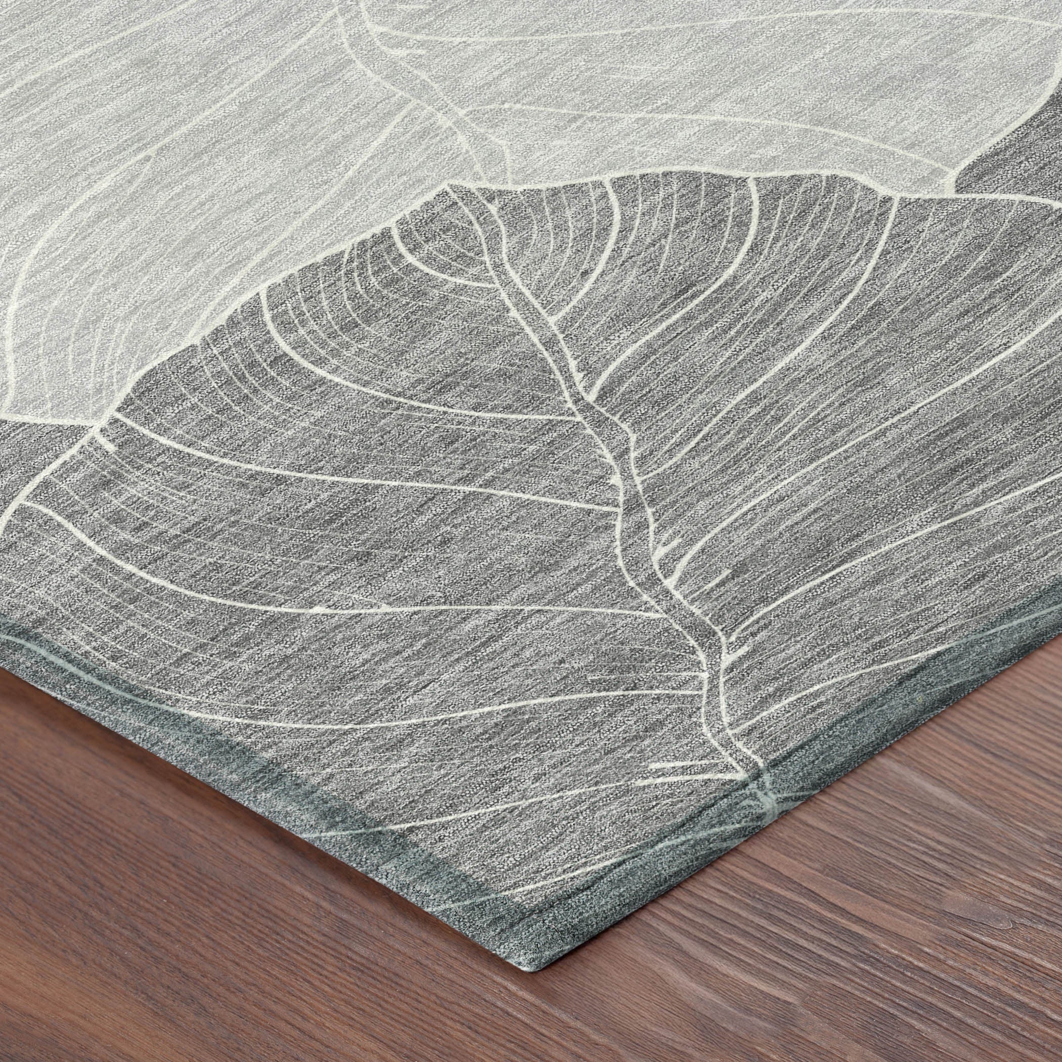 Corner view of gray and ivory leaf-pattern area rug with flat textured weave