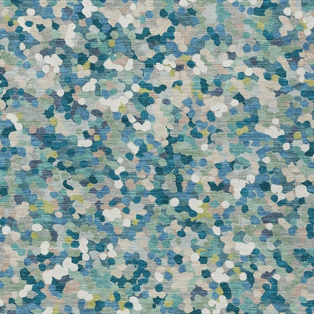 Close-up of teal blue geometric rug with white and blue abstract speckle pattern