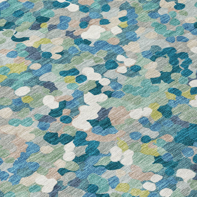Teal blue geometric rug close-up with layered abstract shapes in white, green, and blue