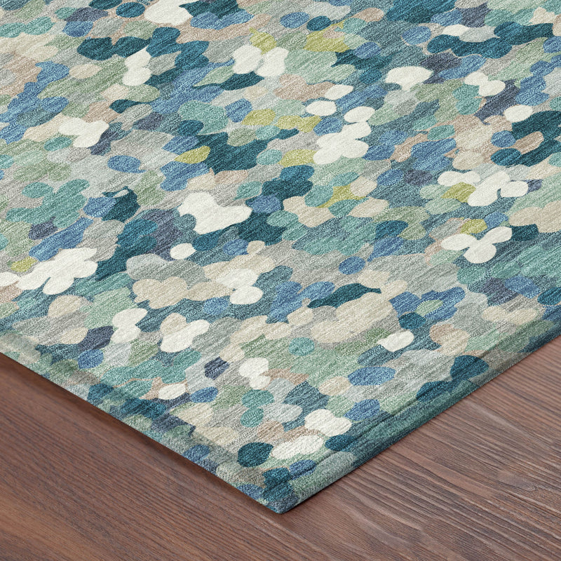 Corner view of teal blue area rug with abstract geometric pattern and short pile