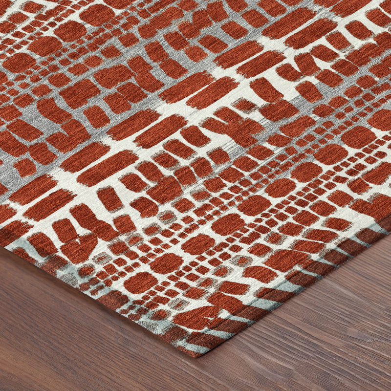 Abstract area rug corner on wood floor, red and gray brick pattern on beige