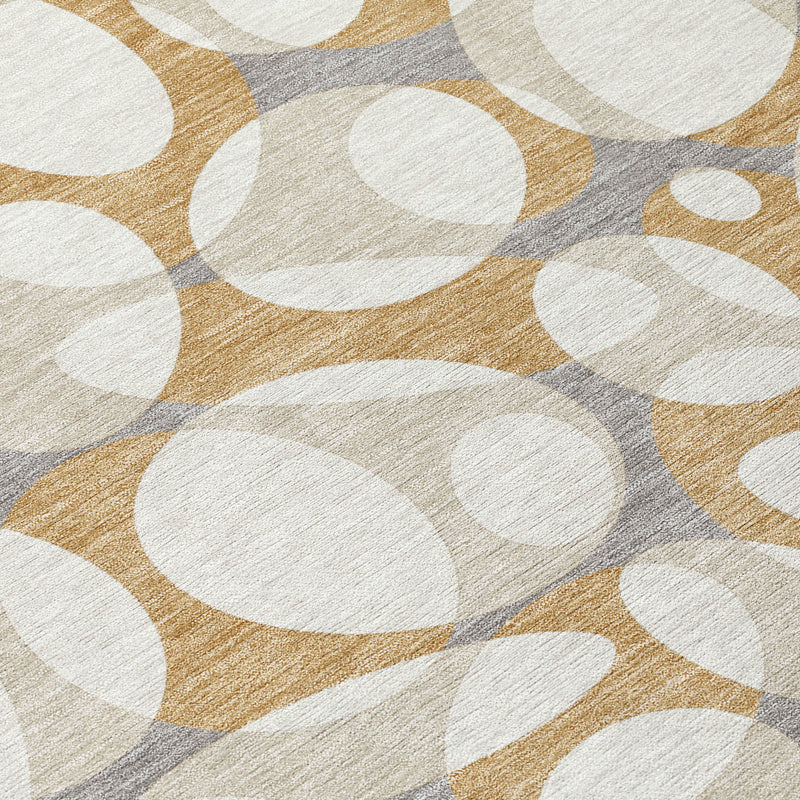 Abstract area rug close-up with white ovals on gold, beige, and gray with light border