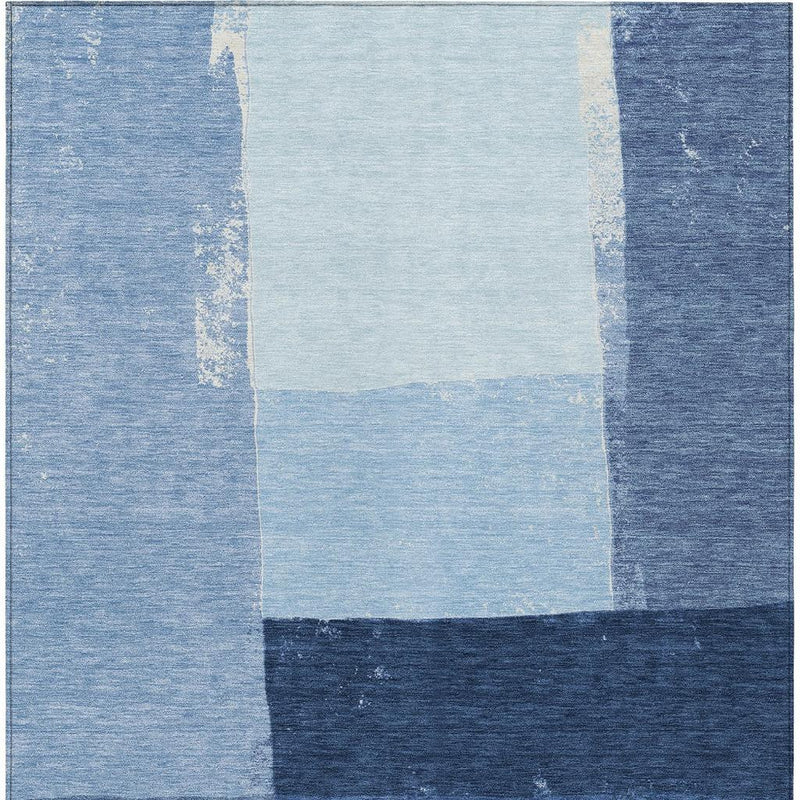 Blue geometric patchwork area rug with light center and dark bottom band
