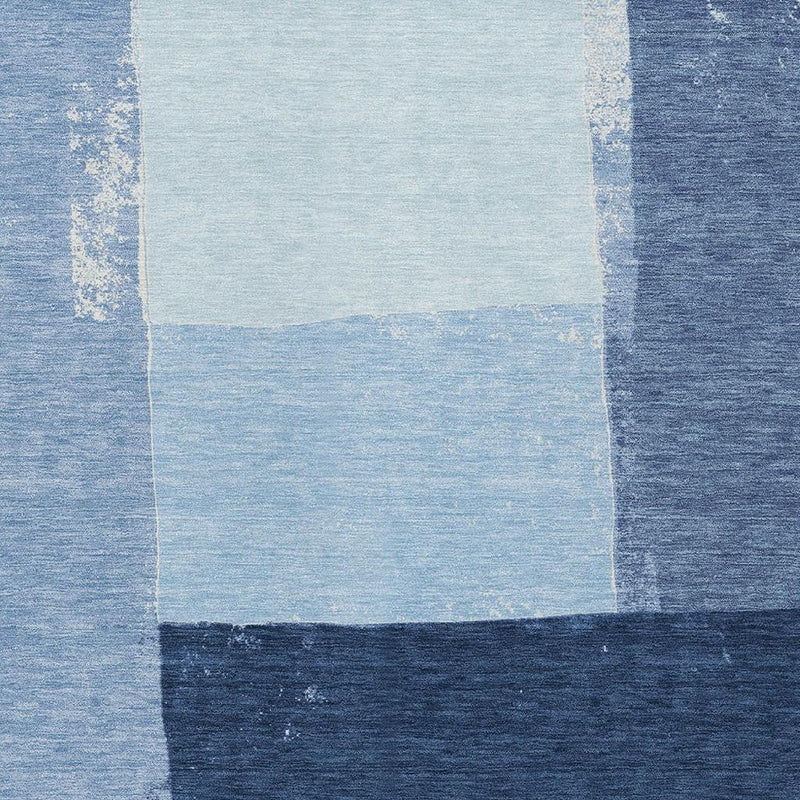 Blue geometric area rug center detail, off-white square with distressed pattern