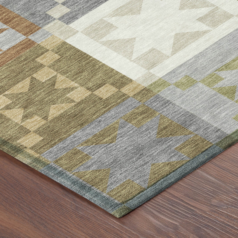 Corner view of round patchwork area rug with geometric pattern in gray, green, and tan tones.