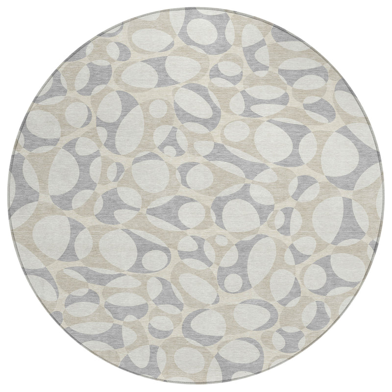 Round abstract indoor outdoor rug with repeating ivory and light gray pattern