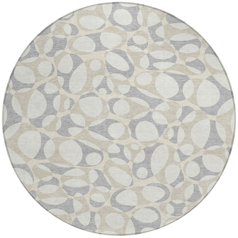 Round abstract area rug with ivory, beige, and light gray oval motifs
