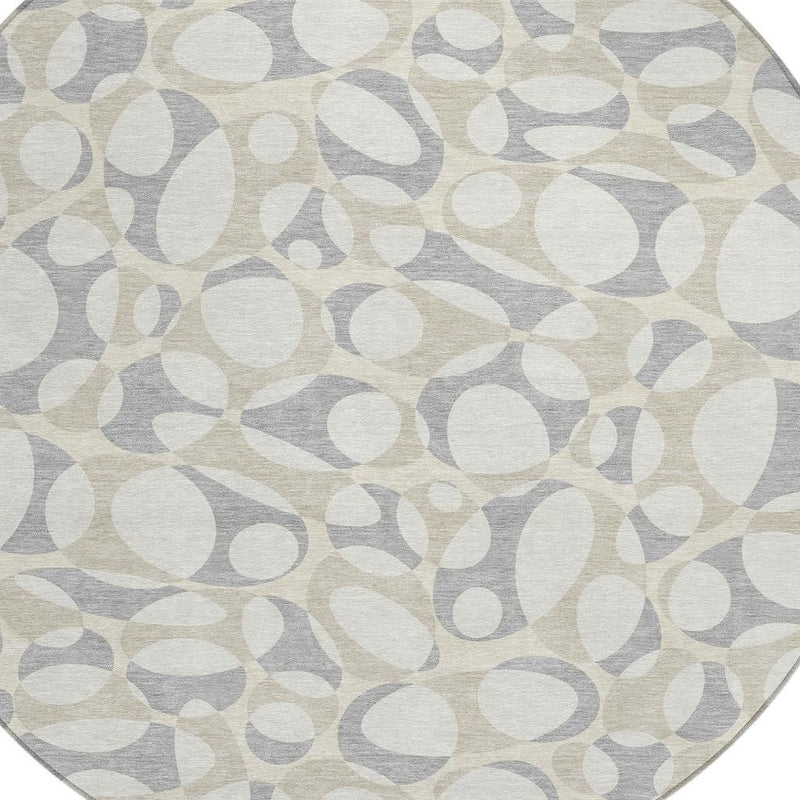 Round abstract indoor outdoor rug in ivory and light gray with textured oval pattern