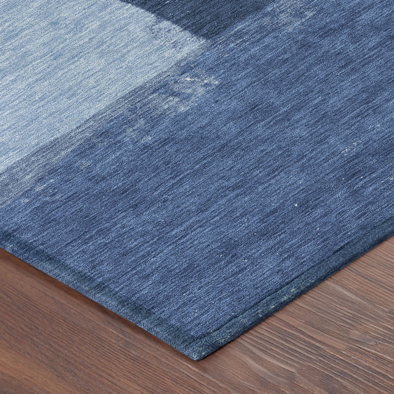 Round blue area rug corner with distressed geometric stripes and textured weave