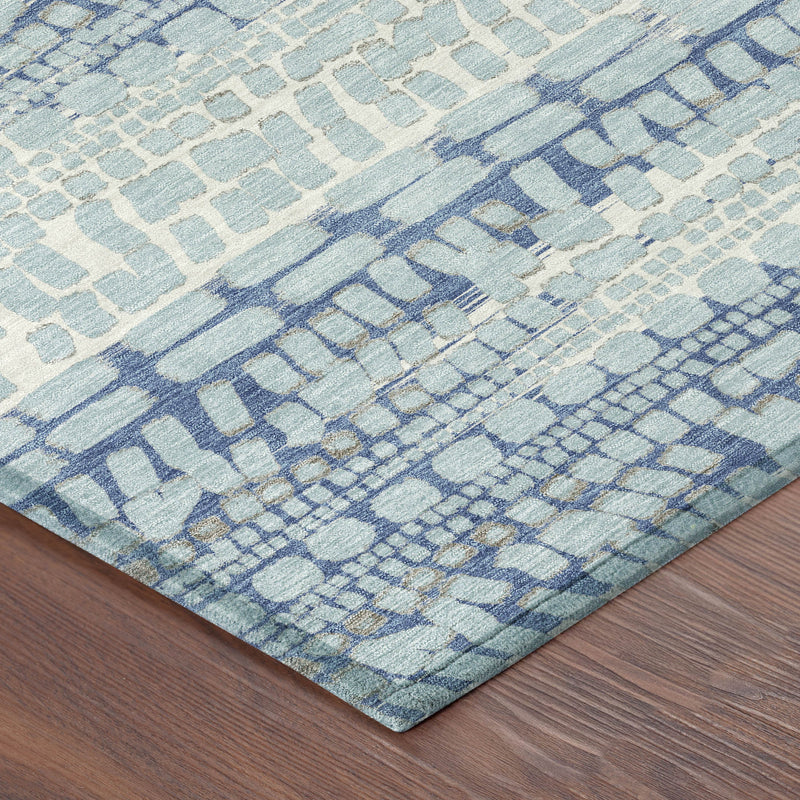 Corner of sky blue and blue abstract area rug with textured woven pattern