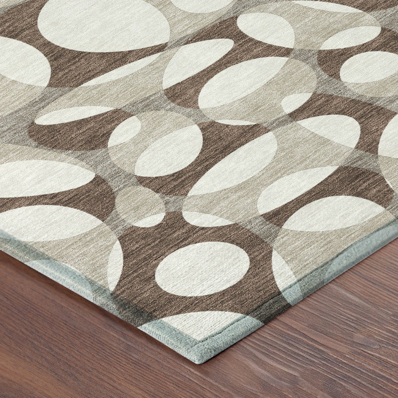 Abstract oval area rug in chocolate brown and beige with visible folded corner