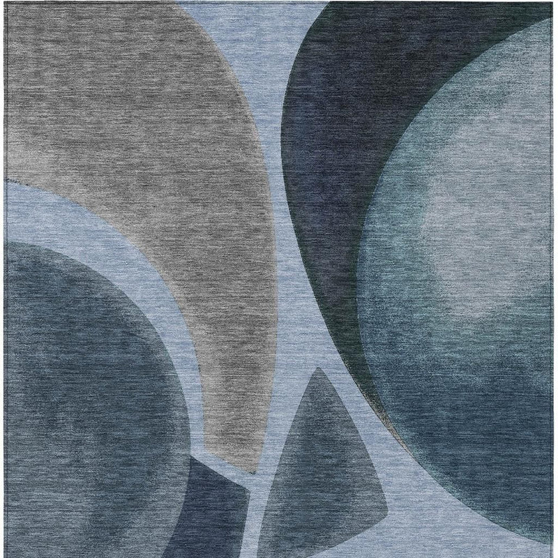 Abstract area rug with blue and gray geometric swirls and light blue arcs