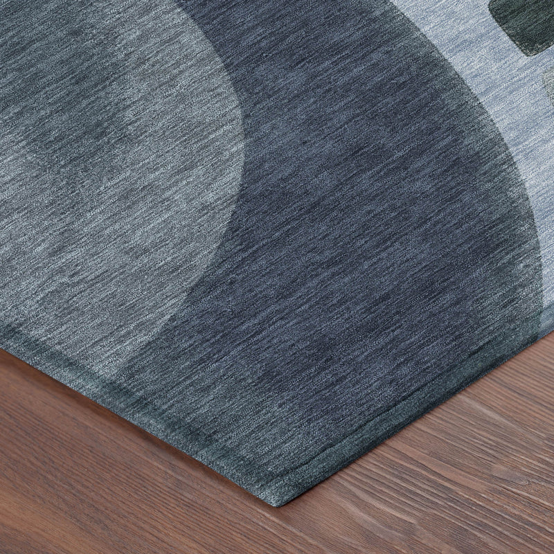 Abstract area rug corner with blue and gray abstract pattern on wood floor