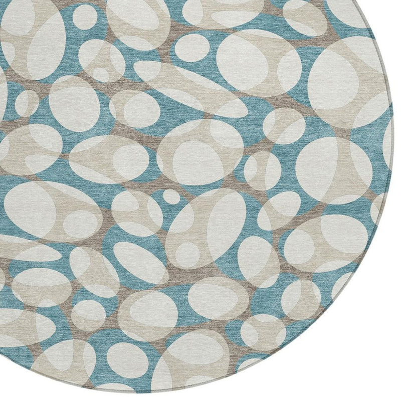Close-up of round area rug pattern: teal blue and ivory abstract ovals