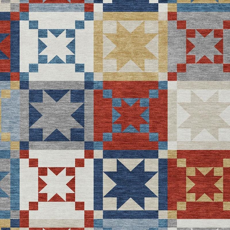 Patchwork area rug detail with white, blue, red and gold star-and-square blocks