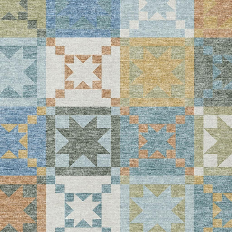 Close-up patchwork area rug with square star designs in blue, green, tan, and white