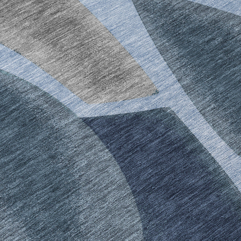 Round abstract rug close-up, blue and navy geometric curves on textured gray