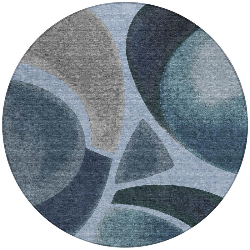 Round abstract area rug with overlapping blue, navy, and gray arc shapes