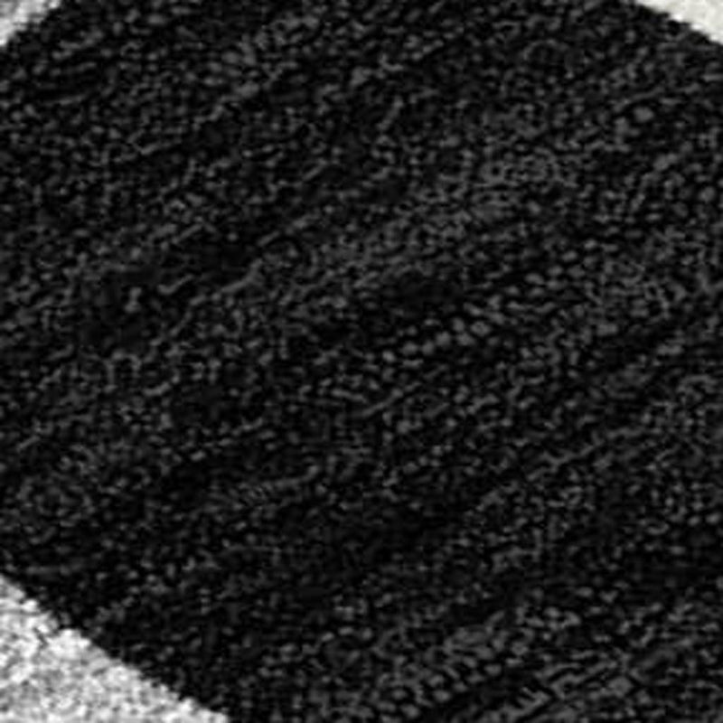 Black round area rug pile texture close-up with tight speckled weave