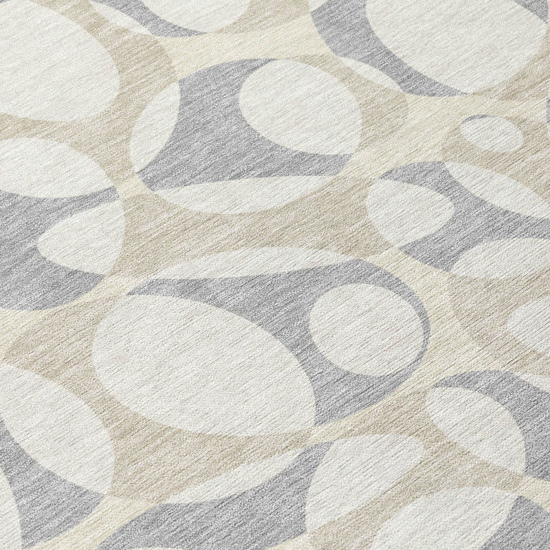Close-up indoor-outdoor rug with repeating oval pebble motif in ivory and light gray