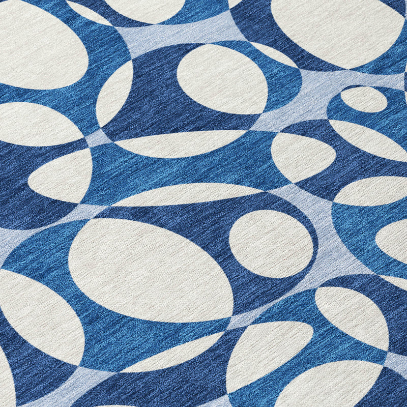 Close-up: blue textured ground with white oval motifs on abstract area rug