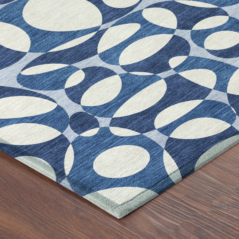 Blue and navy abstract area rug corner with rolled edge and light border trim