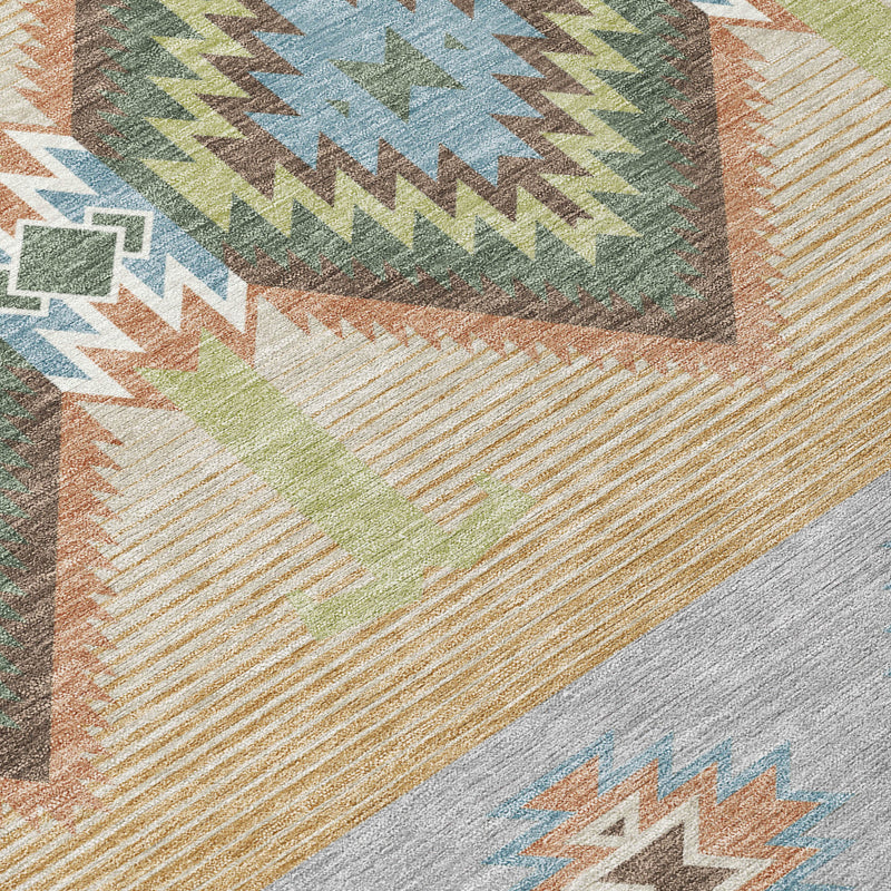 Close-up of round rug pattern in tan, green, and blue with zigzags and diamonds