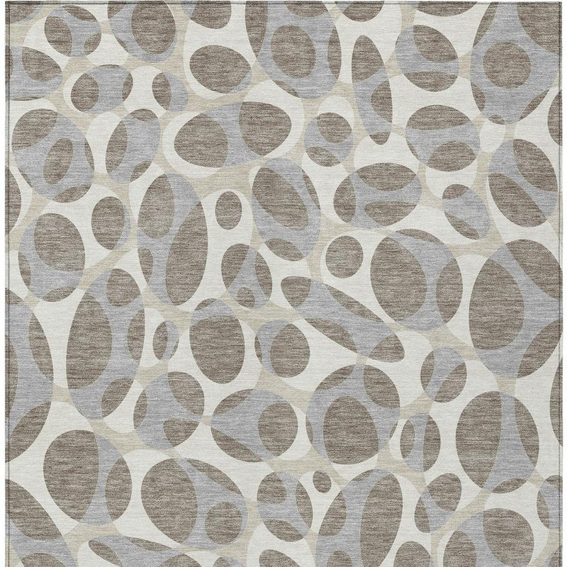 Abstract area rug close-up with taupe and brown oval pattern on light ground