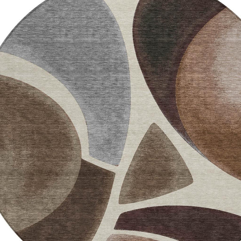 Close-up abstract round area rug with gray, beige, and dark brown curved forms