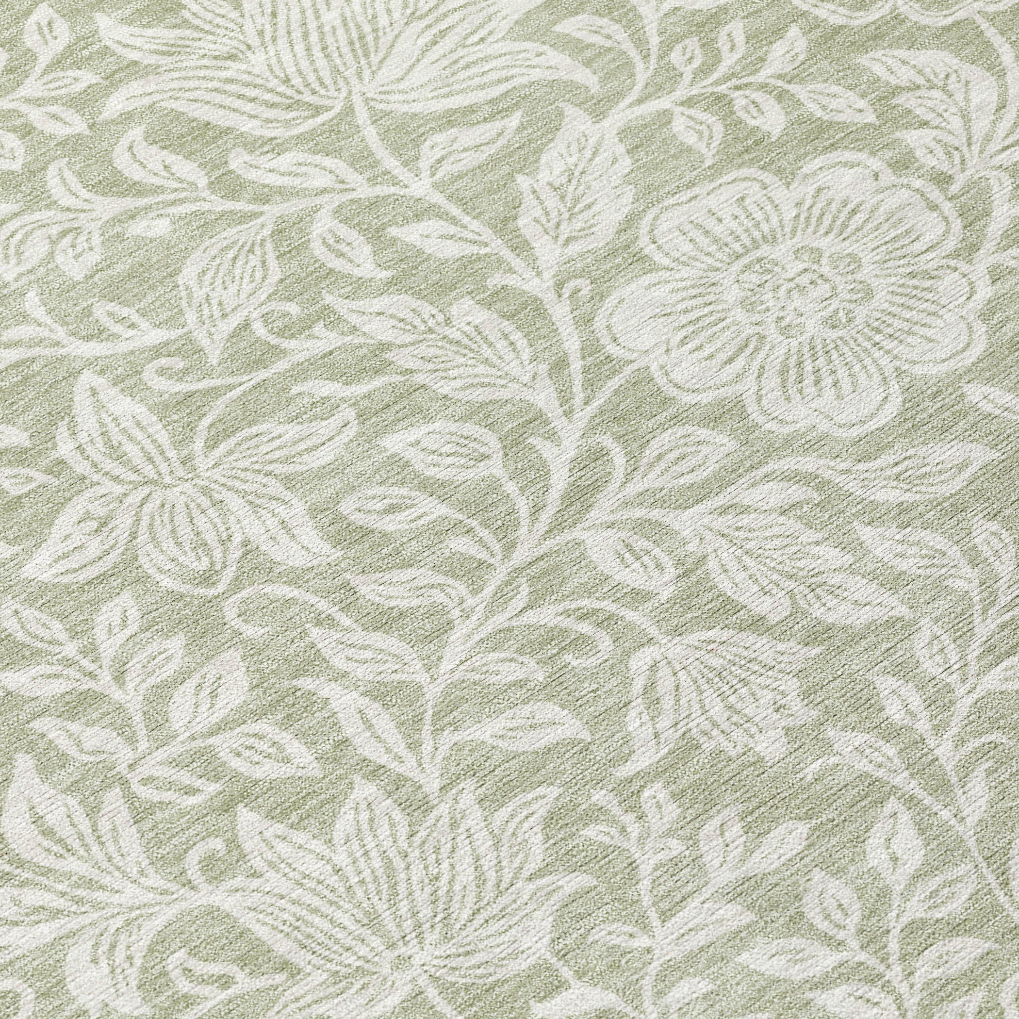 Green and ivory floral rug close-up with detailed leaves and blossoms in faded pattern