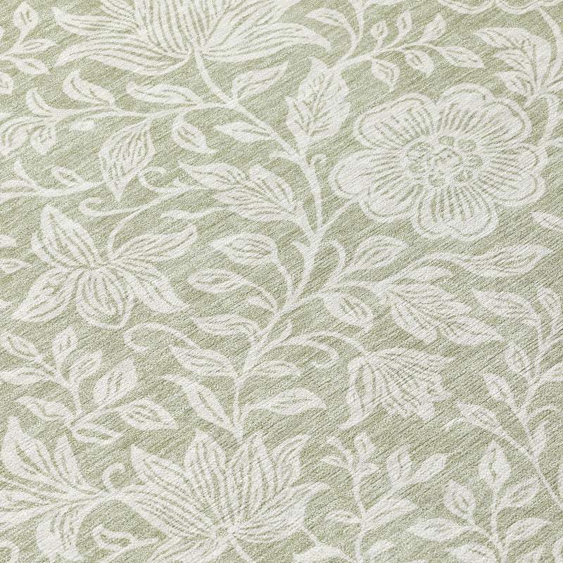 Green and ivory floral rug close-up with detailed leaves and blossoms in faded pattern