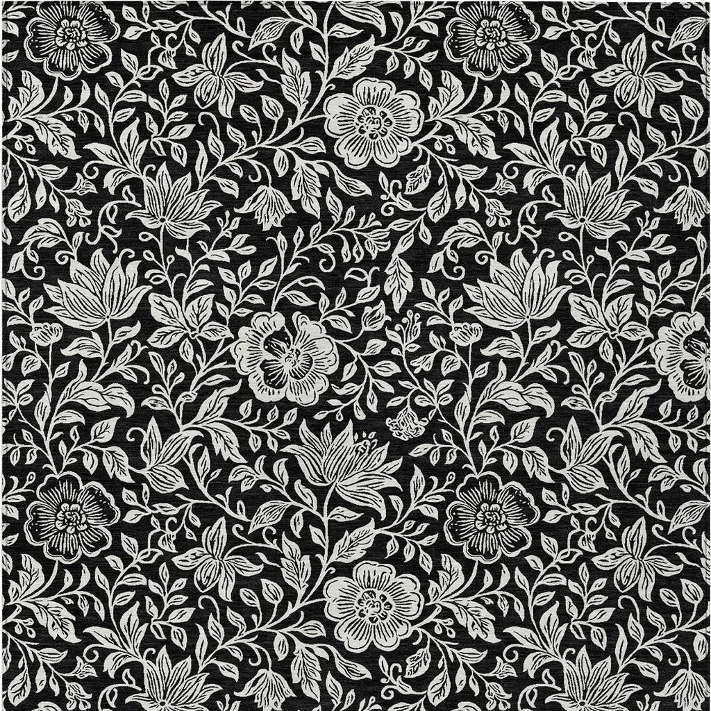 Black and ivory floral area rug with ivory flower clusters and leafy vines