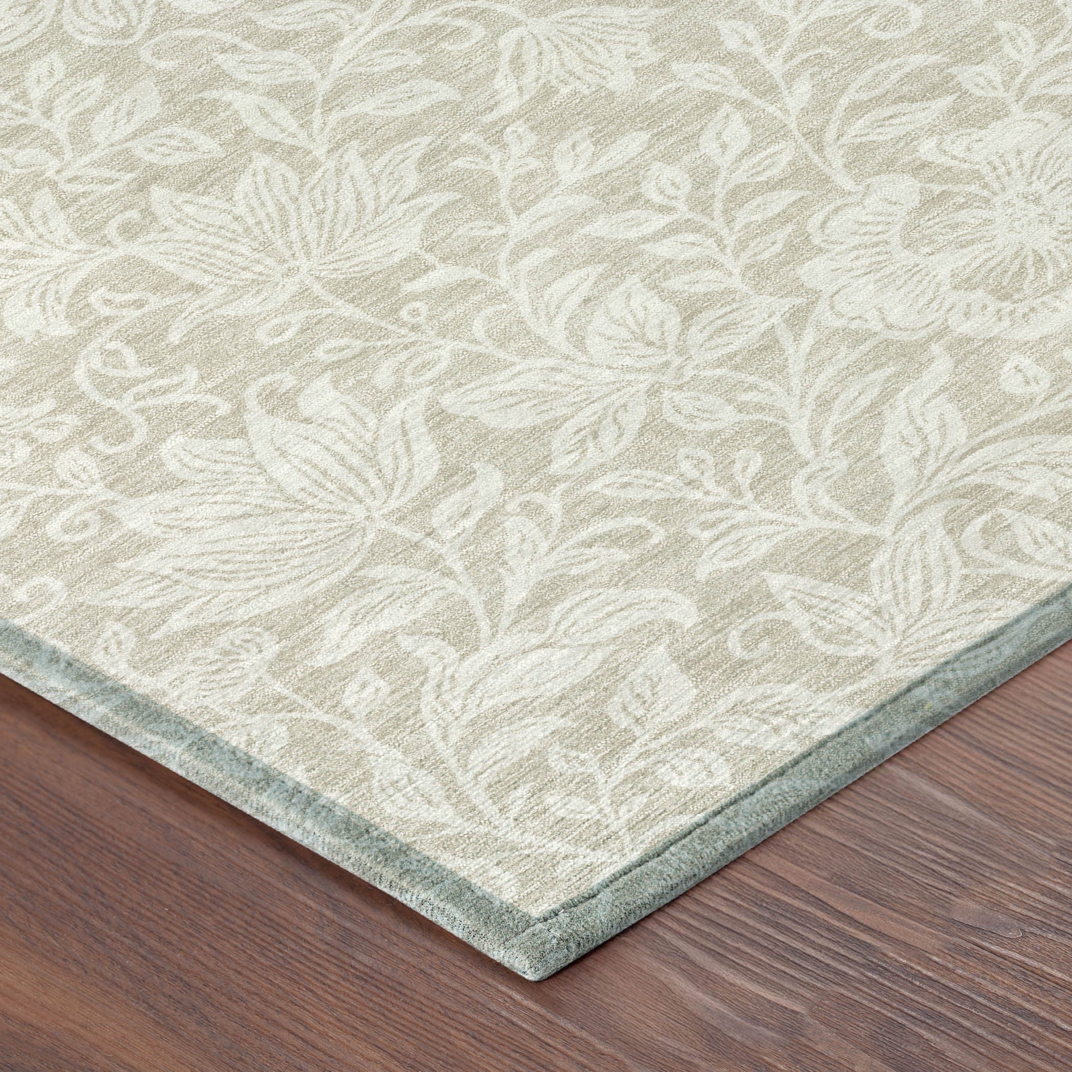 Beige and ivory floral washable area rug corner with light border edging